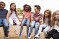 Elementary school friends sitting on a spinning carousel Royalty Free Stock Photo