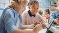 In the Elementary School: Girl and a Boy Work as a Team Using Tablet Computers, Learning Programmi Royalty Free Stock Photo