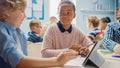 In the Elementary School: Girl and a Boy Work as a Team Using Tablet Computers, Learning Programmi Royalty Free Stock Photo