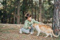 Elementary school kid petting feeding a stray cat in the city park. Child boy playing with abandoned homeless street cat Royalty Free Stock Photo