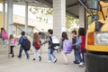 Elementary school kids arrive at school from the school bus Royalty Free Stock Photo