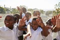 Elementary school kids in playground waving to camera Royalty Free Stock Photo