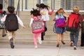 Elementary school kids running into school, back view Royalty Free Stock Photo