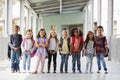 Elementary school kids stand in corridor looking at camera Royalty Free Stock Photo