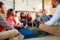 Elementary school kids and teacher sit cross legged on floor Royalty Free Stock Photo