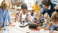 Elementary School Science Classroom: Cute Little Girl Looks Under Microscope, Boy Uses Digital Royalty Free Stock Photo