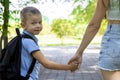 An elementary school student on his way to study. A first grader holds his mother& x27;s hand. The beginning of classes Royalty Free Stock Photo