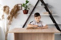 elementary school student reading a book or textbook sitting in the classroom at the table or in the home office. Back Royalty Free Stock Photo