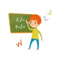 Elementary school student standing near the blackboard and writing mathematical examples, education and knowledge Royalty Free Stock Photo