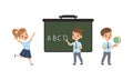 Elementary School Students Studying at Lesson, Cute Boys and Girls Standing on front of Blackboard, Back to School Royalty Free Stock Photo