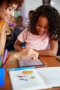 Elementary School Teacher And Female Pupil Drawing Using Digital Tablet In Classroom Royalty Free Stock Photo