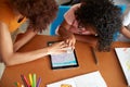 Elementary School Teacher And Female Pupil Drawing Using Digital Tablet In Classroom Royalty Free Stock Photo