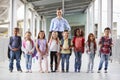 Elementary school teacher and her pupils in school corridor Royalty Free Stock Photo