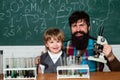 Elementary school teacher and student in classroom. Experiment. Teacher helping pupils studying at desks in classroom Royalty Free Stock Photo