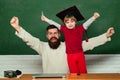 Elementary school teacher and student in classroom. Yay. Smiling broadly. Woohoo. Family generation. Dad and son having Royalty Free Stock Photo