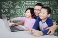 Elementary school teacher using laptop with students Royalty Free Stock Photo