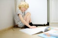 Elementary student boy doing homework on a floor at home. Child learning, doing exercises in workbook. Math and language tutorial Royalty Free Stock Photo