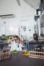 Elementary student doing experiment with blue chemical at laboratory