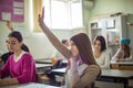 Young Elementary students raising their arms on a class Royalty Free Stock Photo