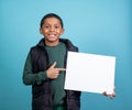 Elementery school hispanic boy looking at the camera holding a sign