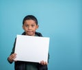 Elementery school hispanic boy looking at the camera holding a sign