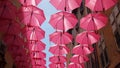 Elements of architecture of Grasse with pink umbrellas between houses.