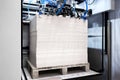 Elements of corton boxes are collected in stack. Conveyor line for the production of boxes. Machine cuts cardboard boxes from shee