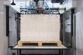 Elements of corton boxes are collected in stack. Conveyor line for the production of boxes. Machine cuts cardboard boxes from