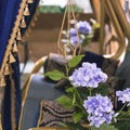 Elements and details of garden and home decor and interior. Golden blue background with purple flowers of hydrangea and fabric