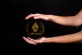 Elements of the ethereum cryptocurrency fall on the hand