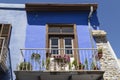 Blue balcony, decorated with flowers on a bright day. Cyprus.