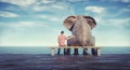 Elephant and a man sitting on bench admiring the sea Royalty Free Stock Photo