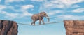 Elephant walks on slackline rope above a gap between two mountain peaks Royalty Free Stock Photo