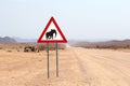 Wild desert elephant warning road sign, Himba people huts, Namibia Royalty Free Stock Photo