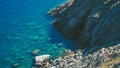 Elevate designs with a serene stock image of a blue beach and rocks