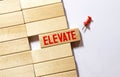 Elevate word written on wood block, concept Royalty Free Stock Photo