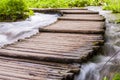 Elevated curved wooden planks path through the rough water streams in Plitvice Royalty Free Stock Photo