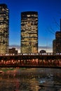 Elevated `el` train crosses Chicago River during evening rush hour in Chicago.