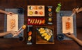 Top view of couple enjoying Japanese cuisine various side dishes by chopstick. Philadelphia, Tuna uramaki, Flower sush set,