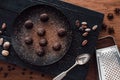 elevated view of cutting board with truffles on plate covering by grated chocolate, spoon, cocoa beans, nutmegs, anise and grater Royalty Free Stock Photo