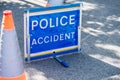 Large Police Accident sign on the road beside two traffic cones.