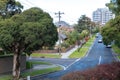 Elevated view of a quiet suburban street with trees, Australian homes and a modern apartment buildings in the distance. Royalty Free Stock Photo