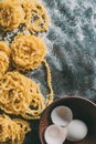 elevated view of raw pasta, bowl with egg and egg shell on table covered Royalty Free Stock Photo