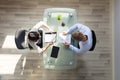 Elevated View Of Two Businesspeople Holding Resume