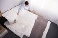 Elevated View Of Housekeeper Arranging Bed