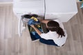 Elevated View Of A Woman Loading Clothes In Washing Machine Royalty Free Stock Photo