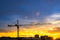 Elevating construction crane against the background of the sunset sky. Royalty Free Stock Photo