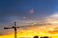 Elevating construction crane against the background of the sunset sky. Royalty Free Stock Photo