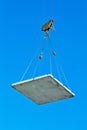 Elevating crane lifting a concrete plate