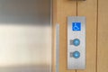 Elevator buttons with Braille codes and handicap sign. Allow signs for up and down